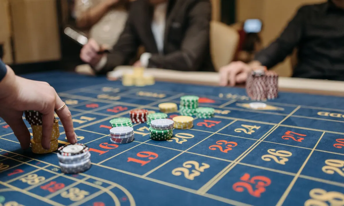 Spieler setzen Chips auf einen Roulettetisch